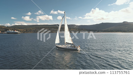Brodick Harbour, Arran Island, Scotland. Slow motion sailboat race at ocean bay aerial. Summer cruise on luxury yacht. Passenger ship at sea shore. Sail boat at unbelieveble seascape Brodick Harbour, Arran Island, Scotland. Slow motion sailboat race at ocean bay aerial. Summer cruise on luxury yacht. Passenger ship at sea shore. Sail boat at unbelieveble seascape 113755761