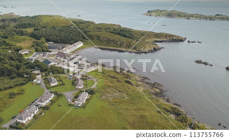 Laphroaig distillery, Port town Ellen, Islay Island, United Kingdom, Europe. Pine trees forest at sea bay. Nobody nature landscape. Alcohol industry building and warehouses at countryside Laphroaig distillery, Port town Ellen, Islay Island, United Kingdom, Europe. Pine trees forest at sea bay. Nobody nature landscape. Alcohol industry building and warehouses at countryside 113755766