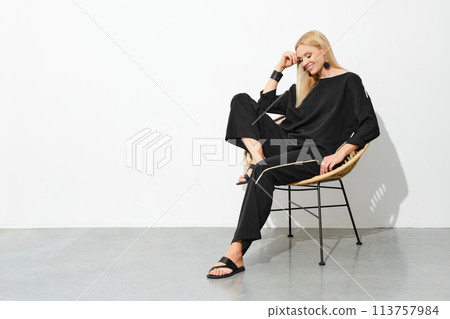 Smiling blonde woman in black home clothes Smiling blonde woman in black home clothes 113757984
