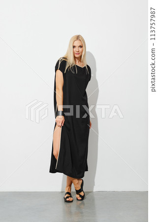 Charming blonde woman in black sleeveless dress Charming blonde woman in black sleeveless dress 113757987