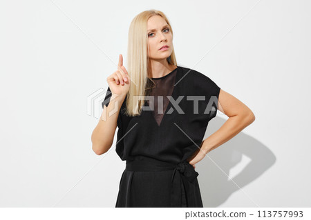 Woman attracts attention by raising her index finger up Woman attracts attention by raising her index finger up 113757993
