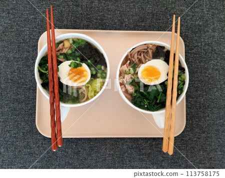 Asian ramen soba noodle soup close up with chicken, boiled egg, nori, green spinach and green onion served with chopsticks Asian ramen soba noodle soup close up with chicken, boiled egg, nori, green spinach and green onion served with chopsticks 113758175
