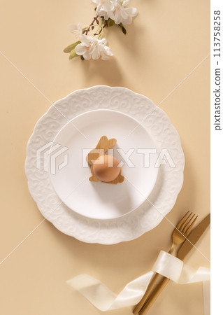 Easter table setting background with white plate, cookies, eggs and bunny. 113758258
