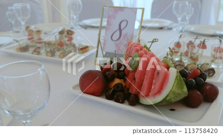 Elegant table setting in a luxurious restaurant. Luxurious banquet tables prepared for the official ceremony. A round table without food is served with plates, napkins, glasses and cutlery. Elegant table setting in a luxurious restaurant. Luxurious banquet tables prepared for the official ceremony. A round table without food is served with plates, napkins, glasses and cutlery. 113758420