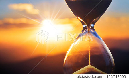 Close-up of a Transparent Hourglass with Blurry Sky at Sunset or Sunrise - Generative Ai 113758603