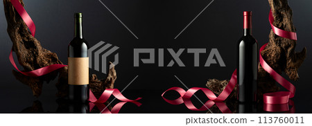 Bottles of red wine on a black reflective background. 113760011