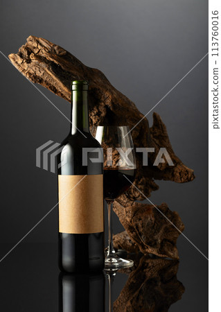 Bottle and glass of red wine on a black reflective background. Bottle and glass of red wine on a black reflective background. 113760016