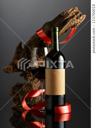 Bottle with old empty label and glass of red wine. Bottle with old empty label and glass of red wine. 113760018