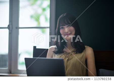 Young woman using a laptop in her bedroom Young woman using a laptop in her bedroom 113760158