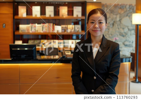 Confident businesswoman greeting customers at modern hotel reception area 113760293
