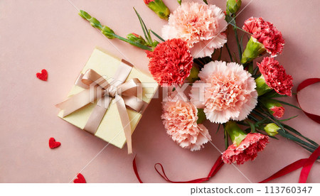 Bouquet of red carnations and a gift 113760347