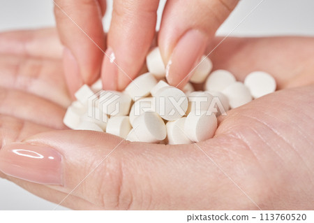 Many pills in the palm of a hand 113760520