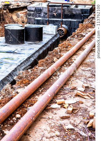 Construction works on large iron pipes at a depth of excavated trench 113762100