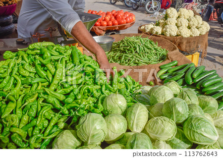 Hand of seller taking different vegetables in street market at Jodhpur Hand of seller taking different vegetables in street market at Jodhpur 113762643
