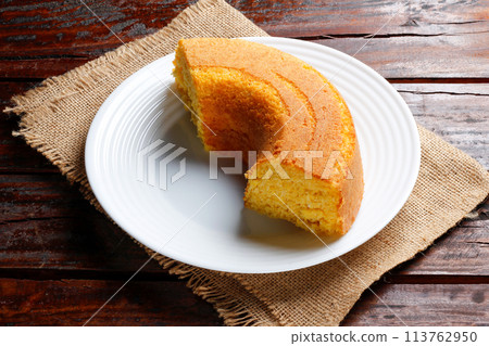 Corn Cake With Coconut white plate on rustic wooden table. Typical Brazilian party food. 113762950