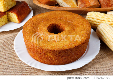 corn cake on white plate on rustic wooden table. Typical Brazilian party food. 113762979