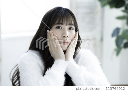 A young woman feels her skin become more moisturized A young woman feels her skin become more moisturized 113764912