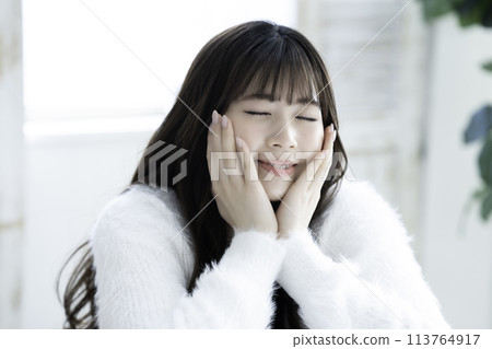 A young woman feels her skin become more moisturized 113764917