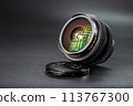 Fisheye camera lens with vivid reflections, set on lens cap, professional photography equipment, clear focus on the text and intricate lens design. 113767300