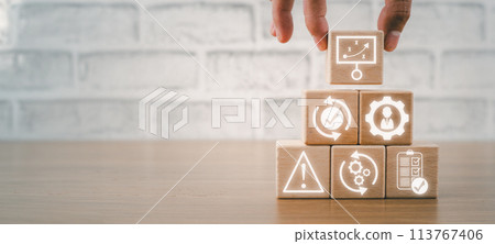 Business continuity concept, Hand holding wooden block on desk with planning, recovery, management, risk, operation and procedures icon on virtual screen. Business continuity concept, Hand holding wooden block on desk with planning, recovery, management, risk, operation and procedures icon on virtual screen. 113767406