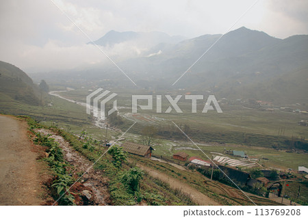A misty view of Lao Cai Village in a valley with a river flowing through, surrounded by mountains. Sa pa, Vietnam A misty view of Lao Cai Village in a valley with a river flowing through, surrounded by mountains. Sa pa, Vietnam 113769208