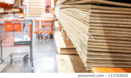 Selective focus on corner edge of stacked plywood at a lumberyard hardware store. 113769880