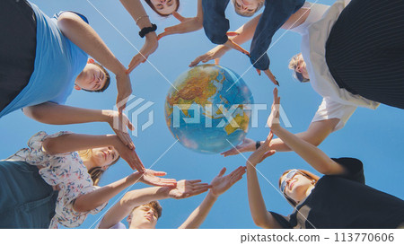 Young friends surround the globe of the world with their palms. The concept of preserving world peace. Young friends surround the globe of the world with their palms. The concept of preserving world peace. 113770606