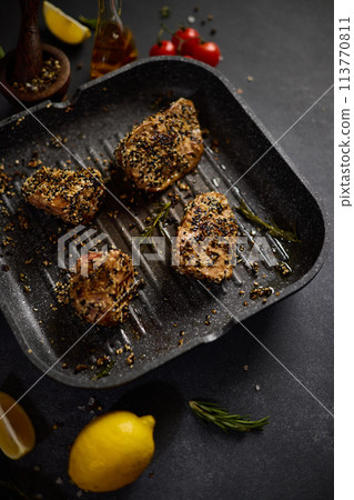 pieces of Organic Tuna fillet covered with sesame seeds frying on a hot grill pan pieces of Organic Tuna fillet covered with sesame seeds frying on a hot grill pan 113770811