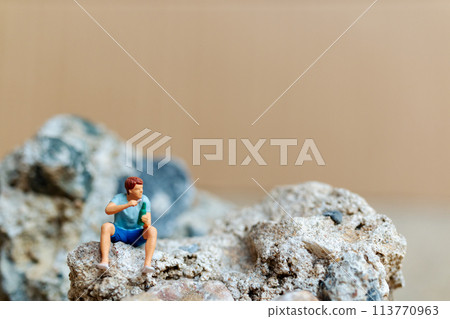 Miniature people , A young man sipping beer and smoking cigarettes 113770963
