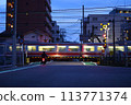 A motorbike waiting for a train to pass at a railroad crossing 113771374