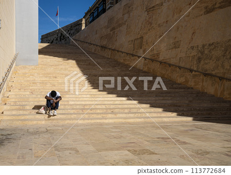a man sitting on the steps a man sitting on the steps 113772684