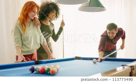 Group of young friends smiling playing billiards Group of young friends smiling playing billiards 113773490