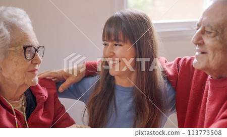 Grandparents and granddaughter looking at each other with love 113773508