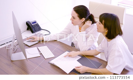 Colleagues discussing about medical report using computer in the clinic 113773554