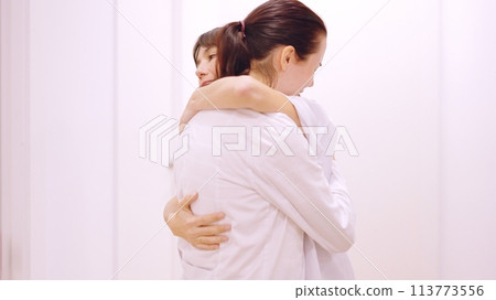 Doctor crying receives a hug and support from her coworker 113773556