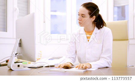 Female doctor typing using computer in a clinic 113773557