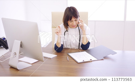 Doctor speaking on the phone celebrating a successful procedure 113773563
