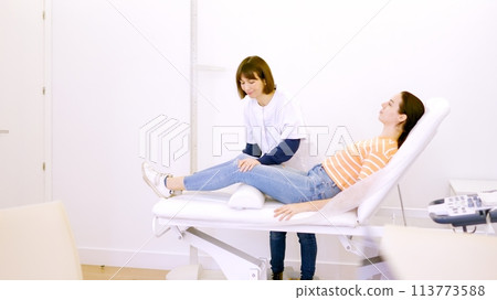 Patient lying on a stretcher attended by a friendly nurse 113773588