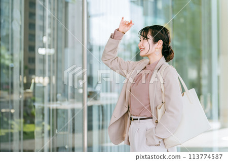 年輕的亞洲女商人在城市的辦公區散步 年輕的亞洲女商人在城市的辦公區散步 113774587