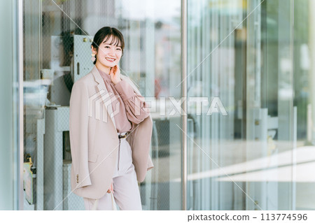 一位年輕的亞洲女商人（模特兒/時尚模特兒）在城市的辦公區行走 113774596