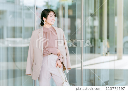 Young Asian business woman (model, fashion model) walking in an urban office district 113774597