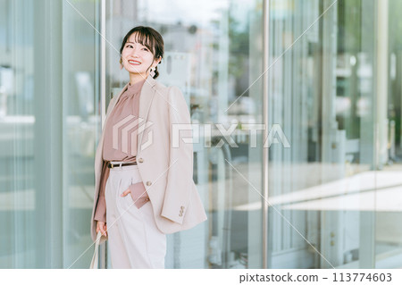 年輕的亞洲女商人在城市的辦公區散步 113774603