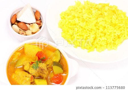 Nepalese soup curry with zucchini, potatoes, chicken and yellow rice on a light background Nepalese soup curry with zucchini, potatoes, chicken and yellow rice on a light background 113775680