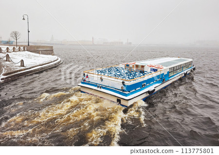 Pleasure boat on the Neva river in a spring snowstorm. St. Petersburg. 113775801