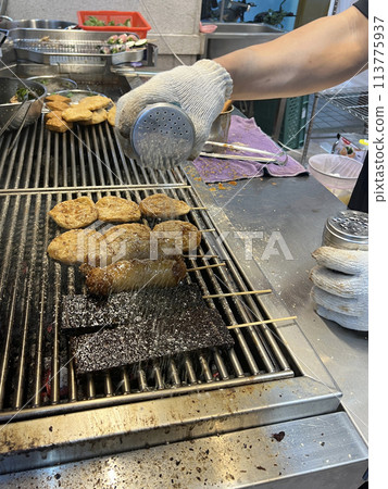 拍攝販賣燒烤的攤販正在為燒烤撒上胡椒與白芝麻 113775937