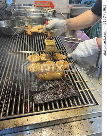 拍攝販賣燒烤的攤販正在為燒烤塗上烤肉醬 113775962