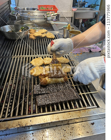 拍攝販賣燒烤的攤販正在為燒烤塗上烤肉醬 113775966