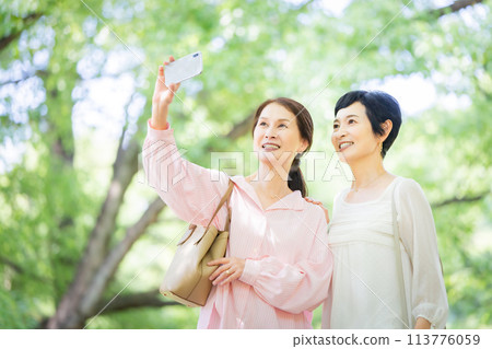 Middle-aged woman taking photos Sightseeing Women's trip 113776059