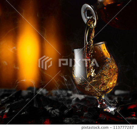 Snifter of brandy on a burning charcoal. Snifter of brandy on a burning charcoal. 113777287