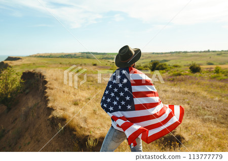 4th of July. American Flag.Patriotic holiday. Traveler with the flag of America. Beautiful sunset light. American style. 4th of July. American Flag.Patriotic holiday. Traveler with the flag of America. Beautiful sunset light. American style. 113777779